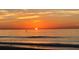 Golden sunrise over a calm ocean with gentle waves meeting the sandy shore at 100 Bluff View Dr # 401A, Belleair Bluffs, FL 33770