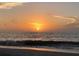 Gentle sunset over a calm ocean with a tranquil beach in the foreground at 100 Bluff View Dr # 401A, Belleair Bluffs, FL 33770