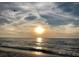 A serene beach scene shows the sun shining over a calm ocean, with a seagull flying above at 100 Bluff View Dr # 401A, Belleair Bluffs, FL 33770