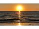 Gorgeous beach view featuring golden sunset reflected on sand and sea with small waves rolling onto the shore at 100 Bluff View Dr # 401A, Belleair Bluffs, FL 33770