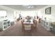 Open concept dining room and living area with carpeted floors at 100 Bluff View Dr # 401A, Belleair Bluffs, FL 33770