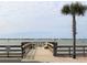 Waterfront dock featuring a shaded bench, railings, and a palm tree with a beautiful water view at 100 Bluff View Dr # 401A, Belleair Bluffs, FL 33770
