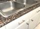 Close up of granite countertops with a stainless steel sink in a kitchen at 100 Bluff View Dr # 401A, Belleair Bluffs, FL 33770
