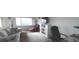 Bright living room features cozy seating, a television, and a bookcase with natural light from a large window at 100 Bluff View Dr # 401A, Belleair Bluffs, FL 33770