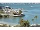 View of the marina with boat docks and a sandy beach area in the foreground, with waterfront homes in the distance at 100 Bluff View Dr # 401A, Belleair Bluffs, FL 33770