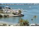 View of the marina with boat docks and a sandy beach area in the foreground, with waterfront homes in the distance at 100 Bluff View Dr # 401A, Belleair Bluffs, FL 33770