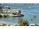 View of the marina with boat docks and a sandy beach area in the foreground, with waterfront homes in the distance at 100 Bluff View Dr # 401A, Belleair Bluffs, FL 33770