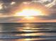 Beautiful ocean view featuring a bright sunset over calm waters under a cloudy sky at 100 Bluff View Dr # 401A, Belleair Bluffs, FL 33770