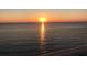 Calm ocean waters at sunset with sun reflection and a sliver of sand along the coastline at 100 Bluff View Dr # 401A, Belleair Bluffs, FL 33770