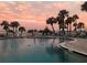Community pool overlooking the ocean, lined with palm trees, lounge chairs, and a ladder to enter the pool at 100 Bluff View Dr # 401A, Belleair Bluffs, FL 33770