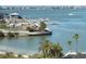 Scenic waterfront view features a marina, palm trees, a sandy beach, and clear blue water on a sunny day at 100 Bluff View Dr # 401A, Belleair Bluffs, FL 33770