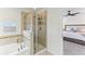 Bathroom view showcasing a glass shower, soaking tub, and nearby primary bedroom entrance at 10144 Arbor Run Dr # 107, Tampa, FL 33647