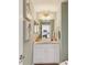 Charming half bathroom with modern vanity, decorative mirror, and neutral color scheme at 10144 Arbor Run Dr # 107, Tampa, FL 33647