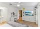 Bright primary bedroom features a vanity, ensuite bath, and tv on wall at 10144 Arbor Run Dr # 107, Tampa, FL 33647