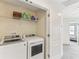 Bright laundry room featuring a white washer and dryer with shelving for storage at 10144 Arbor Run Dr # 107, Tampa, FL 33647