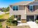 Tan two-story house with a gray door and small front yard at 10428 Rivercrest Dr, Riverview, FL 33578