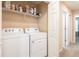 Convenient laundry room with washer, dryer, and shelving at 10428 Rivercrest Dr, Riverview, FL 33578