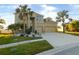 Two-story house with a three-car garage and palm trees at 11016 Holly Cone Dr, Riverview, FL 33569