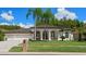 Beautiful house exterior with three-car garage and palm trees at 1257 Kings Way Ln, Tarpon Springs, FL 34688