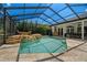 Spacious pool area with a waterfall and screened enclosure at 1257 Kings Way Ln, Tarpon Springs, FL 34688