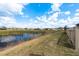 Scenic backyard view with pond and fence, offering a peaceful and private outdoor space at 13387 Crest Lake Dr, Hudson, FL 34669