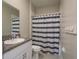 The bathroom features a granite sink and a shower with a striped curtain at 13387 Crest Lake Dr, Hudson, FL 34669