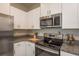 Bright kitchen featuring granite countertops, stainless steel appliances and white cabinetry at 13387 Crest Lake Dr, Hudson, FL 34669