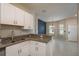 Well-lit kitchen featuring granite countertops, stainless steel appliances, and white cabinets with breakfast bar at 13387 Crest Lake Dr, Hudson, FL 34669