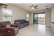 Comfortable living room showcasing tile flooring, neutral walls, a ceiling fan and sliding glass doors to the lanai at 13387 Crest Lake Dr, Hudson, FL 34669