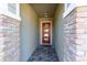 Brick entryway with a modern glass and wood front door at 14015 Kingfisher Glen Dr, Lithia, FL 33547