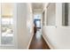 Bright hallway with dark hardwood floors and views into other rooms at 14015 Kingfisher Glen Dr, Lithia, FL 33547