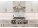 Stainless steel gas cooktop and range hood in modern kitchen at 14015 Kingfisher Glen Dr, Lithia, FL 33547