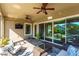 Covered patio with seating area, ceiling fans, and sliding doors at 14015 Kingfisher Glen Dr, Lithia, FL 33547