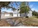Gray two-story house with a white door and attached garage, nestled amongst trees at 1703 Alhambra Crest Dr, Ruskin, FL 33570