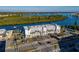 Aerial view of waterfront condo building with parking and tennis courts at 18325 Gulf Blvd # 405, Redington Shores, FL 33708