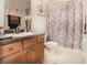 Charming bathroom with floral shower curtain and wood cabinets at 3011 Marble Crest Dr, Land O Lakes, FL 34638