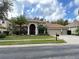 Tan house with red door, three-car garage, and green lawn at 3011 Marble Crest Dr, Land O Lakes, FL 34638