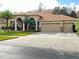 Two-story house with three-car garage, landscaping, and a red door at 3011 Marble Crest Dr, Land O Lakes, FL 34638