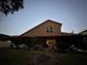 Back exterior view of house at dusk, showing backyard at 3011 Marble Crest Dr, Land O Lakes, FL 34638