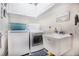 Bright laundry room with washer, dryer, and utility sink at 3011 Marble Crest Dr, Land O Lakes, FL 34638