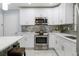 Modern white kitchen with stainless steel appliances and quartz countertops at 3114 W Abdella St, Tampa, FL 33607