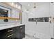 Modern bathroom with black vanity, gold accents, and glass-enclosed shower at 319 26Th W St, Bradenton, FL 34205