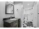 Basement bathroom with black vanity, white subway tile shower, and checkered floor at 319 26Th W St, Bradenton, FL 34205