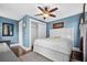 Serene bedroom with white bed frame, ceiling fan, and blue walls at 319 26Th W St, Bradenton, FL 34205