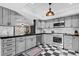Modern kitchen with gray cabinets, checkerboard floor, and stainless steel appliances at 319 26Th W St, Bradenton, FL 34205