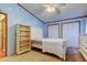 Light blue bedroom with carpet, two closets, and shelving unit next to bed frame at 3841 Julie Dr, Wesley Chapel, FL 33543