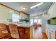 Bright kitchen with breakfast bar, wood floors, white cabinets and dining area at 3841 Julie Dr, Wesley Chapel, FL 33543