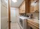 Bright laundry room with washer, dryer, ample cabinetry, and utility sink at 5117 Roanoke Dr, Holiday, FL 34690