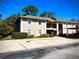 Front view of condo building with landscaping and parking at 5265 E Bay Dr # 410, Clearwater, FL 33764