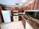 Kitchen with wood cabinets, granite countertops, and stainless steel appliances at 5265 E Bay Dr # 410, Clearwater, FL 33764